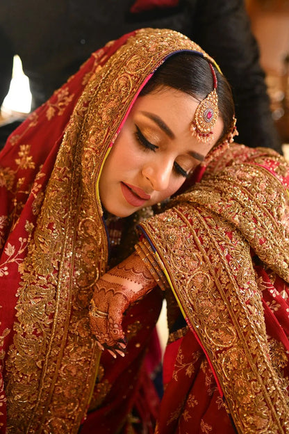 A classic red bridal for Barat, timelessly handcrafted with zardozi, sitara, kamdani, and dabka. The shirt and dupatta are finished with elegant chatapatti, while the dupatta features an all-over handworked jaal and richly embellished borders.
